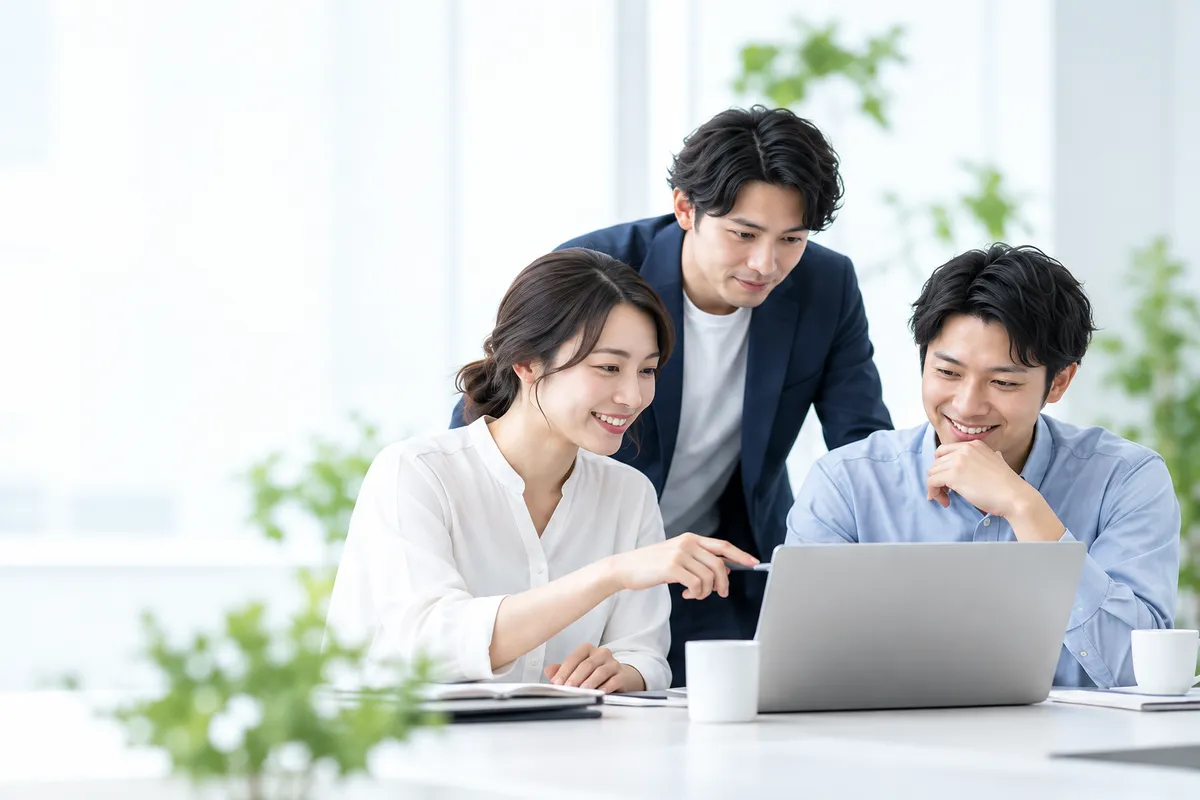 ノートPCを囲んで仕事を進めるチーム
